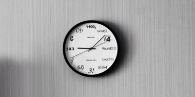 An analog clock with mathematical equations.